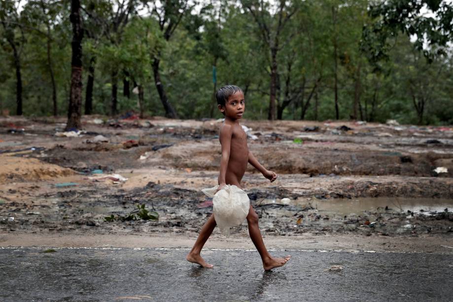 Um garoto rohingya é fotografado andando na chuva pelo acampamento de refugiados Cox' Bazar, em Bangladesh - 20/09/2017