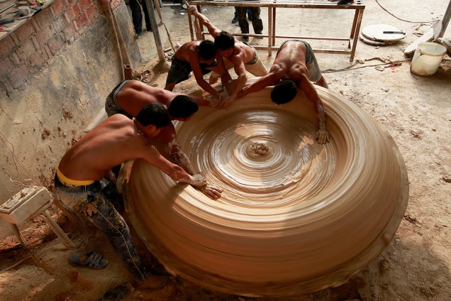Trabalhadores fazem um tonel de porcelana em uma fábrica em Jingdezhen, China - 25/09/2017