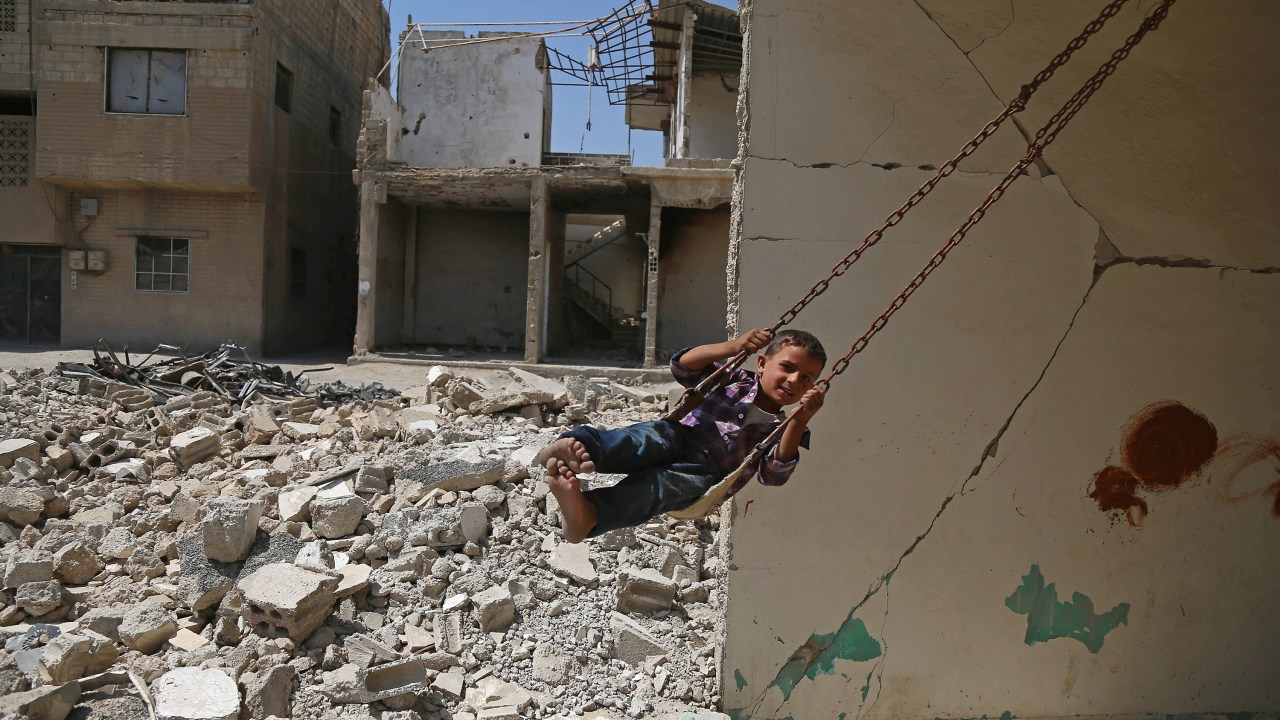 Imagens do dia - Menino brinca em balanço na Síria