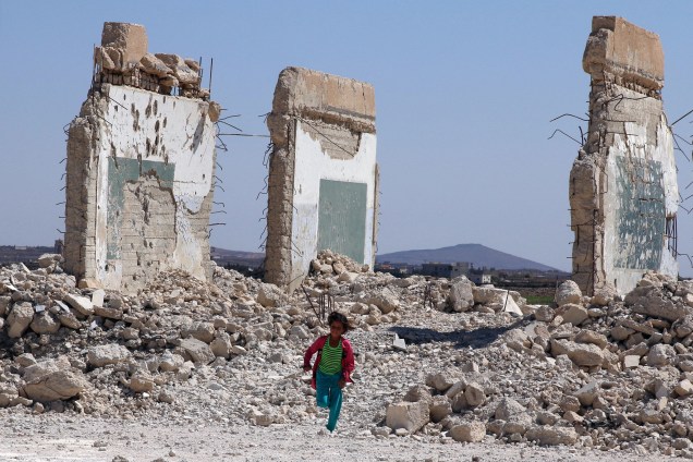 Uma garota é fotografada correndo por entre campos destruídos da cidade de Quneitra, capital do governadorato homônimo, na Síria - 12/09/2017