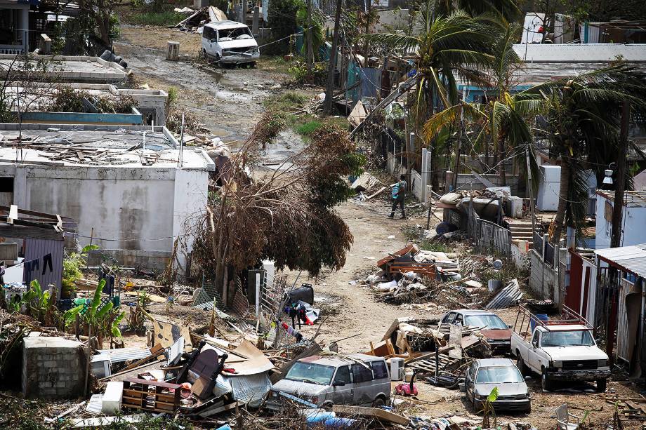 Homem carrega água em um bairro destruído pelo furacão Maria, na cidade de Canovanas, em Porto Rico. Fenômeno causou a morte de pelo menos 43 pessoas - 27/09/2017