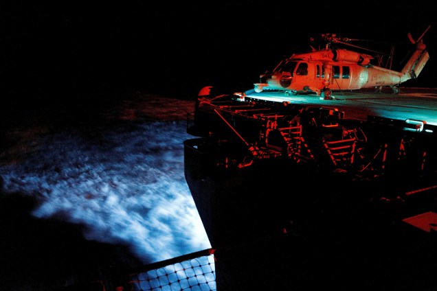 O helicóptero MH-60S Seahawk é fotografado durante a noite na viagem da embarcação porta-aviões USS Kearsarge, com destino ao Caribe para atender às vítimas do furacão Maria - 21/09/2017