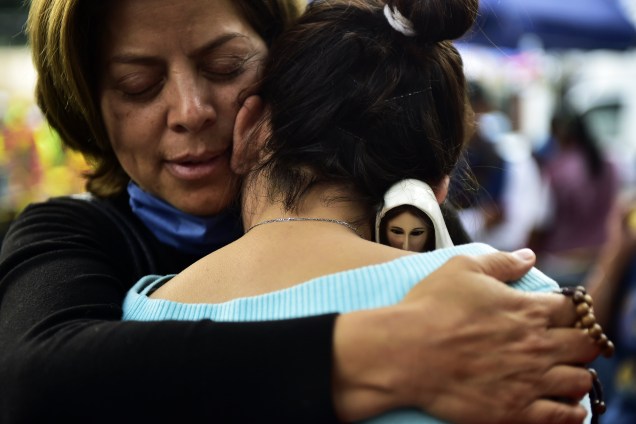 Uma semana após o terremoto que matou mais de 300 pessoas no centro do México, uma mulher com uma imagem de Nossa Senhora de Fátima nas mãos, consola outra pelo desespero de não ter encontrado parentes nos escombros de um prédio que desabou - 27/09/2017