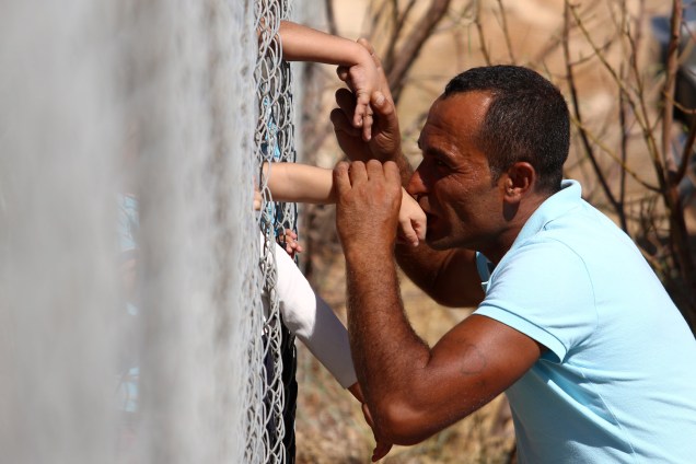 O sírio Ammar Hammasho que mora em Chipre beija as mãos de seus filhos recém chegados ao campo de refugiados em Kokkinotrimithia nos arredores de Nicosia, no Chipre - 10/09/2017