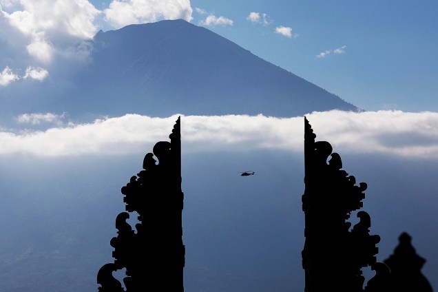 Vulcão do Monte Agung aparece entre nuvens, próximo ao portal de um templo em Karangasem, na ilha de Bali, na Indonésia. Uma série crescente de tremores indica que uma erupção do vulcão é possível num futuro próximo, segundo especialistas - 26/09/2017