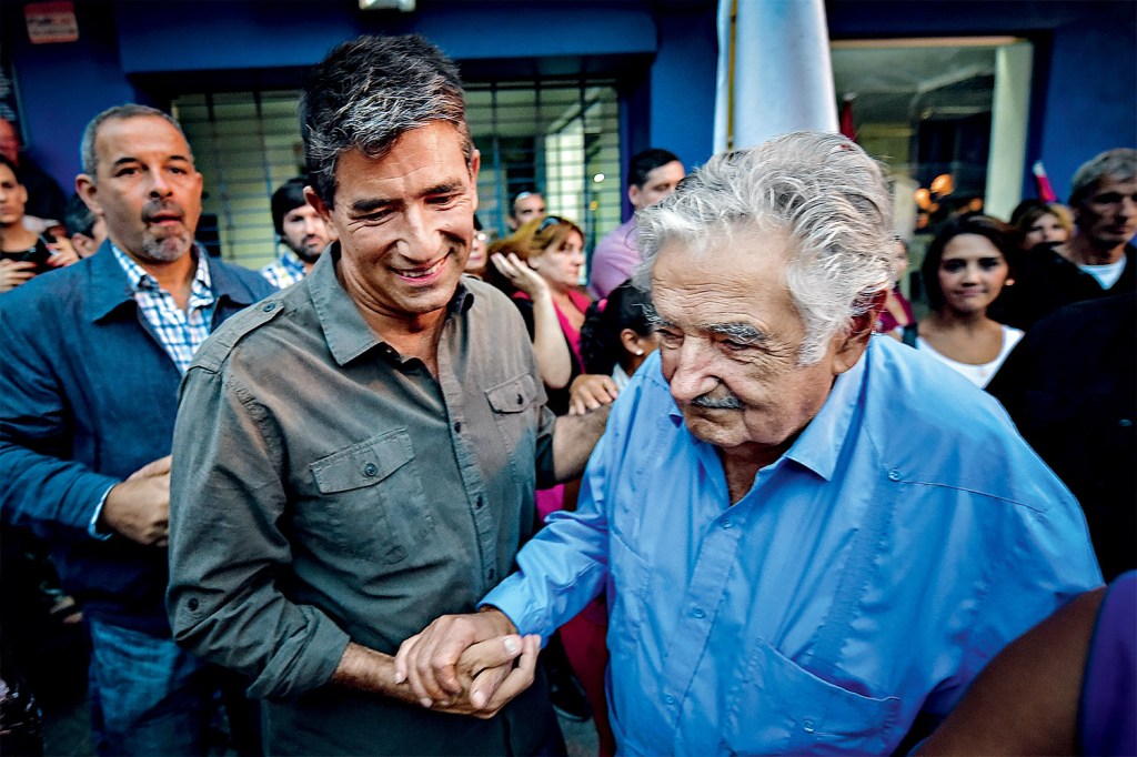 CANELONES, URUGUAY - MARCH 26: The current vice president of the Republic of Uruguay, Raul Sendic (2nd L) shakes hands with Former president and referent of the left in Uruguay, Jose "Pepe 'Mujica (R) as they attend the 46th anniversary celebrations of the establishment of the Frente Amplio in Las Piedras, Canelones on March 26, 2017. 46 years after the first act of the Frente Amplio, literally meaning Broad Front, the main leftist coalition and political force that governed since 2014 in Uruguay, commemorated this date in the city of Las Piedras calling the internal fraternity in the debate of ideas, in the corresponding areas. Carlos Lebrato / Anadolu Agency