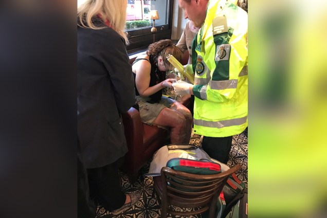 Pessoas do serviço de emergência atendem a uma mulher ferida após uma explosão em um trem na estação de metro Parsons Green, em Londres na Grã-Bretanha - 15/09/2017