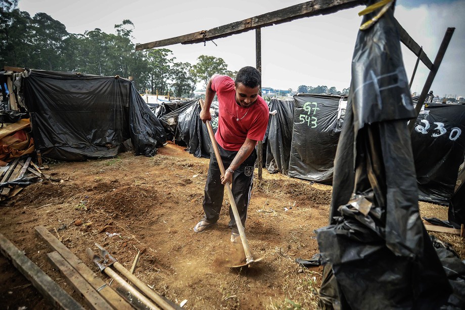Miliante prepara terra para construir uma barraca, durante ocupação do MTST em um terreno em São Bernardo do Campo