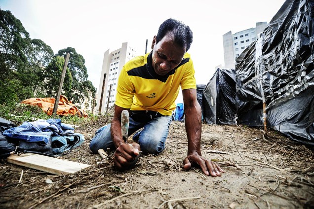 Militante cava buraco para construir uma barraca em ocupação do MTST em um terreno em São Bernardo do Campo