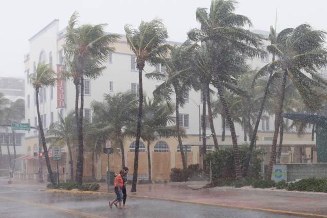 Pessoas caminham pela rua enquanto os ventos e a chuva começam a bater com a aproximação do furacão Irma em Miami Beach, Flórida (EUA) - 09/09/2017
