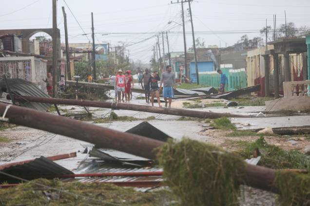Pessoas caminham em uma rua coberta de destroços após passagem do furacão Irma em Caibarien, em Cuba - 09/09/2017