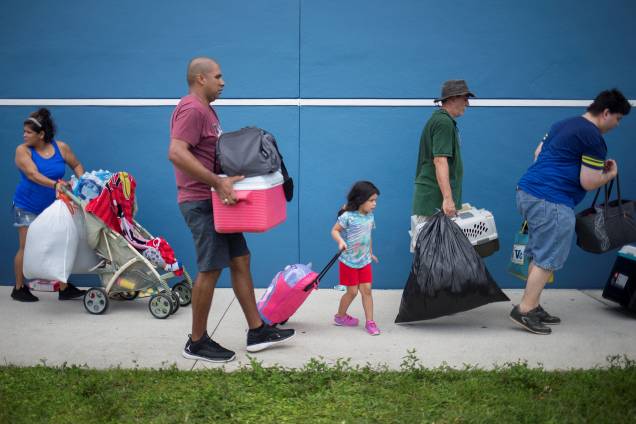 Moradores carregam seus pertences enquanto se dirigem a um abrigo antes da chegada do furacão Irma em Estero na Flórida - 09/09/2017