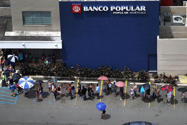 Pessoas aguardam em fila na porta de um banco, após a passagem do furacão Maria, em San Juan, Porto Rico