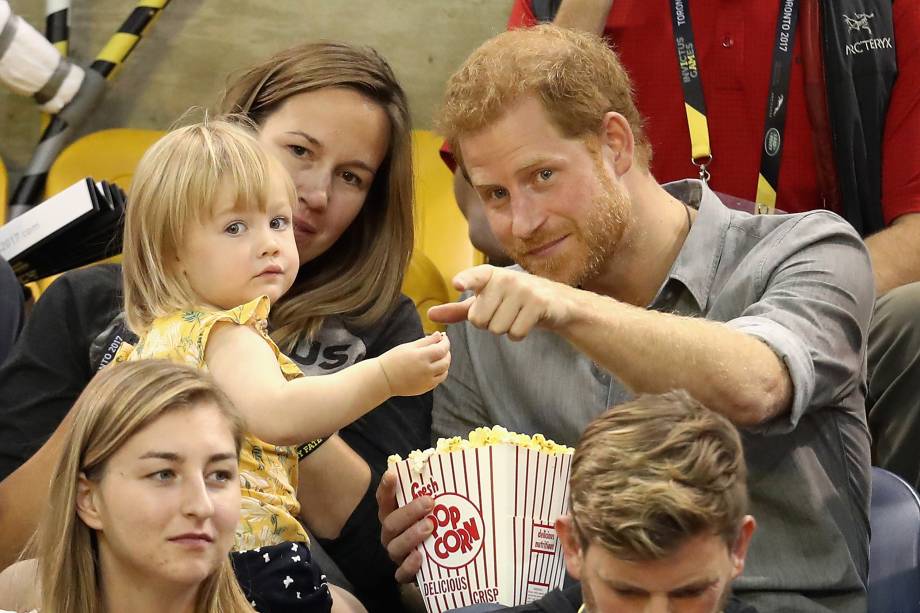 Hayley Henson e a filha Emily Henson sentam-se com o Príncipe Harry para comer pipoca e assistir às finais do vôlei durante os Jogos Invictus 2017 no Centro de Atletismo Mattamy, em Toronto, no Canadá