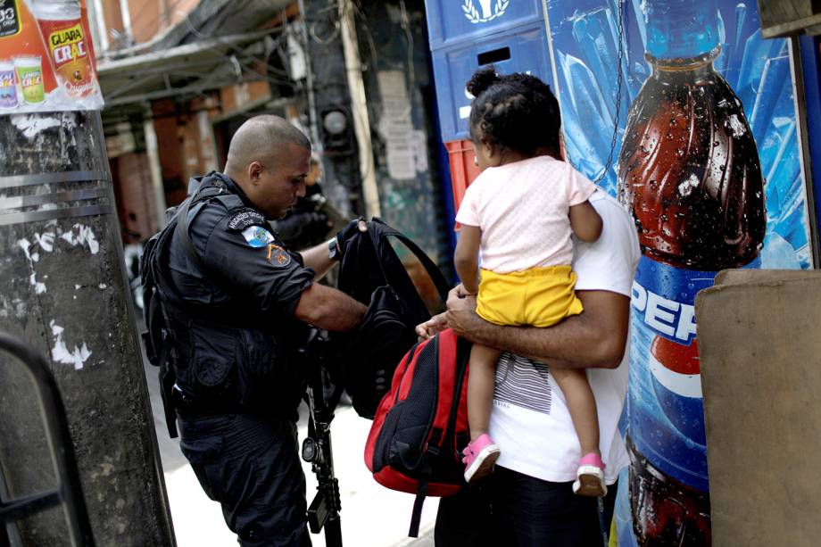 Policial revista morador durante operação na Rocinha, após confronto entre facções por domínio do tráfico, no Rio - 22/09/2017