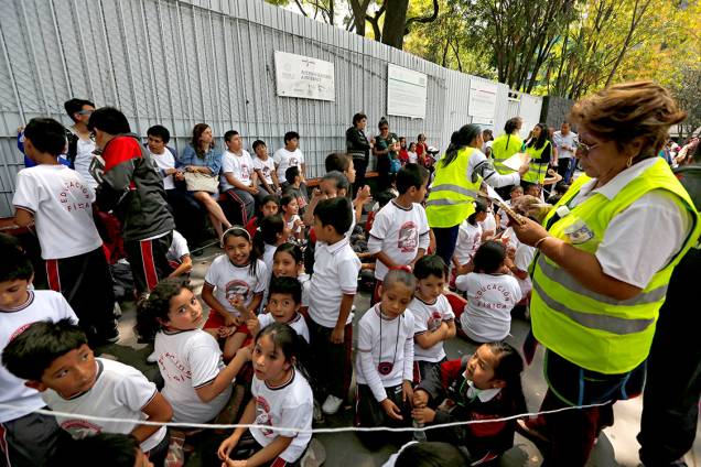 Crianças são reunidas ao longo de uma rua fora da escola, após terremoto atingir a Cidade do México