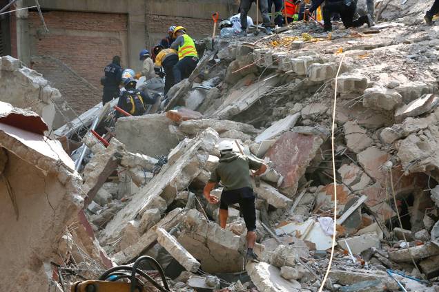 Pessoas sobem em escombros à procura de sobreviventes, na Cidade do México