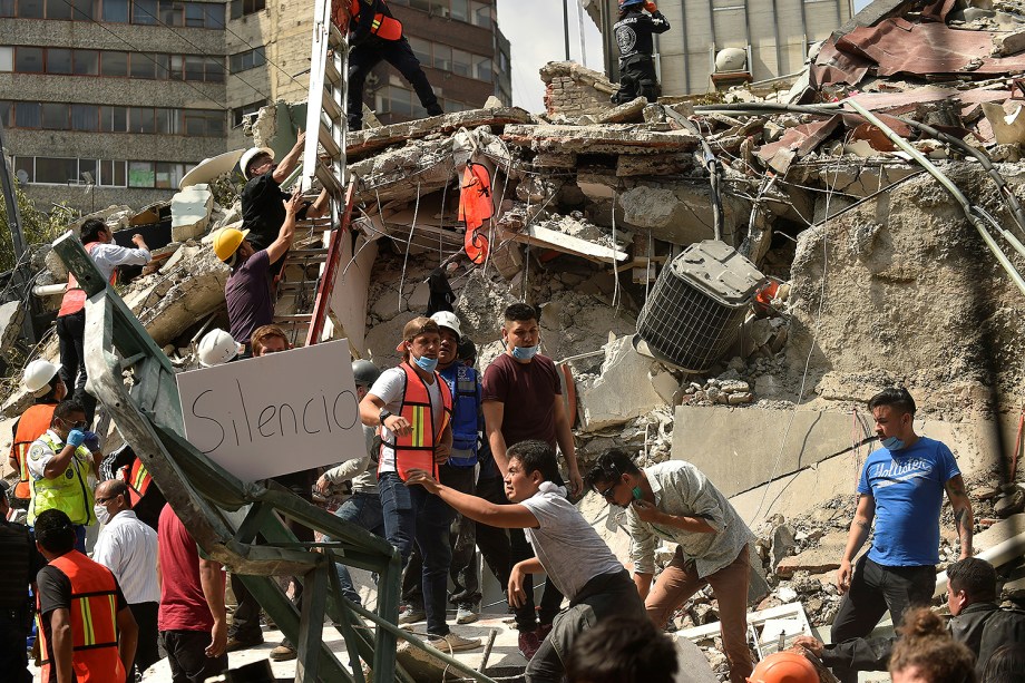 Pessoas mostram um cartaz com o pedido de silêncio, na tentativa de encontrar sobreviventes após terremoto que atingiu o México - 20/09/2017