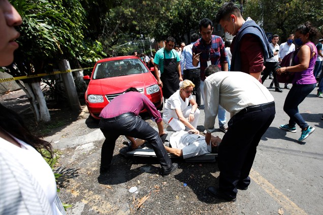 Equipes de resgate e voluntários removem destroços de um prédio que desabou, à procura de sobreviventes, na Cidade do México