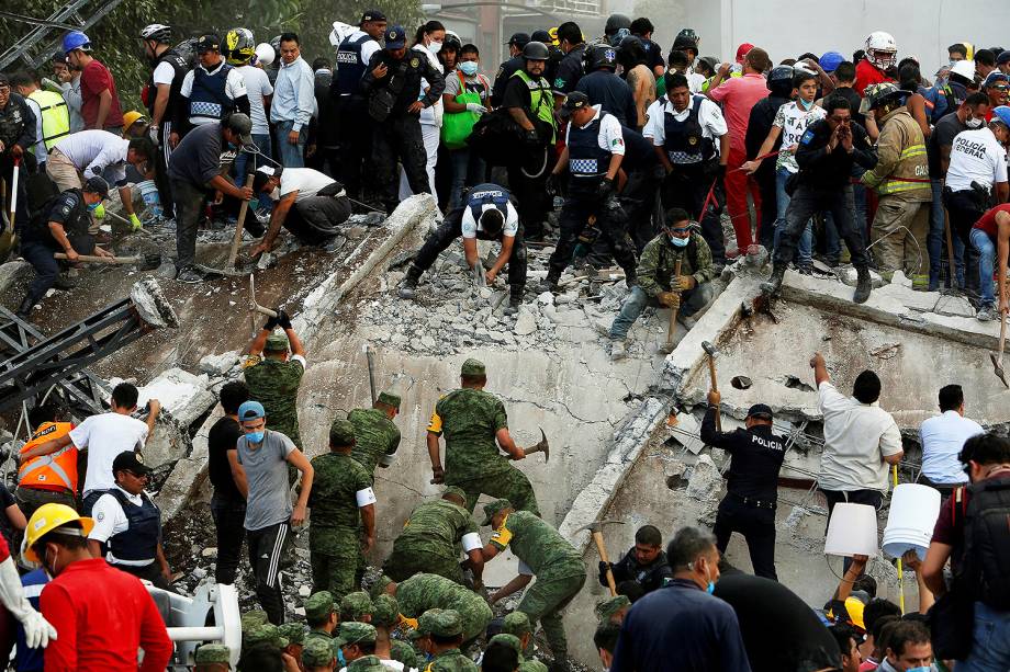 Equipes de resgate e voluntários removem destroços de um prédio que desabou, à procura de sobreviventes, na Cidade do México