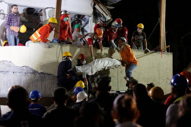 Membros da equipe de resgate removem um corpo após vasculhar os escombros da escola Enrique Rebsamen, na Cidade do México, em busca de sobreviventes do terremoto - 20/09/2017
