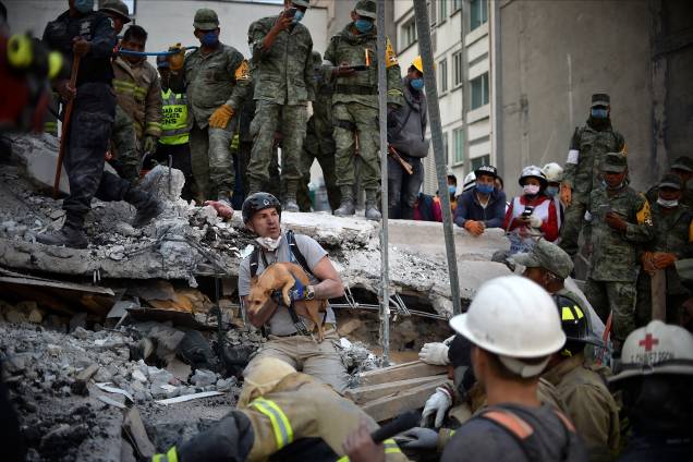 Um homem retira um cachorro dos escombros de um prédio destruído após a passagem de um terremoto na Cidade do México, no aniversário de 32 anos de outro terremoto devastador que ocorreu em 1985 - 20/09/2017