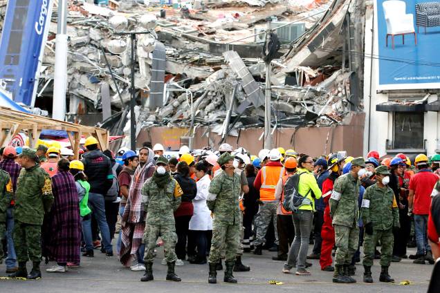 Soldados e equipes de resgate aguardam em uma rua após sentirem um novo terremoto na Cidade do México. Ao fundo, destroços do terremoto que atingiu o méxico na terça-feira (19) - 23/09/2017