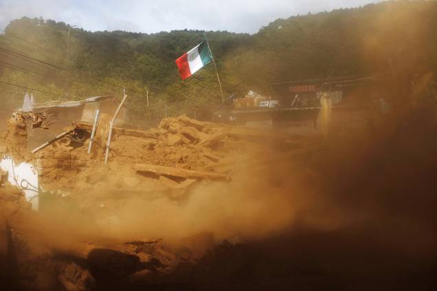 Bandeira do México é erguida em meio a escombros, em Tecomatlan - 23/09/2017