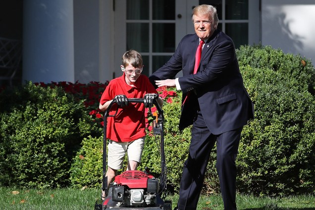 O menino Frank Giaccio, de 11 anos, corta a grama na Casa Branca, ao lado do presidente Donald Trump, Washington - 15/09/2017