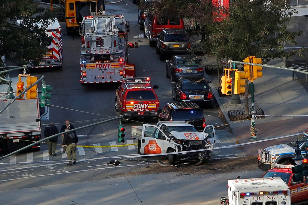 Bombeiros fazem primeiro socorros após motorista de caminhão invadir ciclofaixa, bater em ônibus escolar e seguir atirando pela West Street em Nova York, Estados Unidos