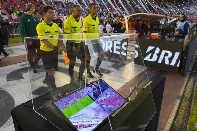 Brazilian referee Wilton Pereira Sampaio (C) and his assistants pass by a screen of the Video Assistant Referee (VAR) before the start of the Copa Libertadores 2017 semifinal first leg football match between Argentina's River Plate and Lanus at the Monumental stadium in Buenos Aires, on October 24, 2017. / AFP PHOTO / Juan MABROMATA