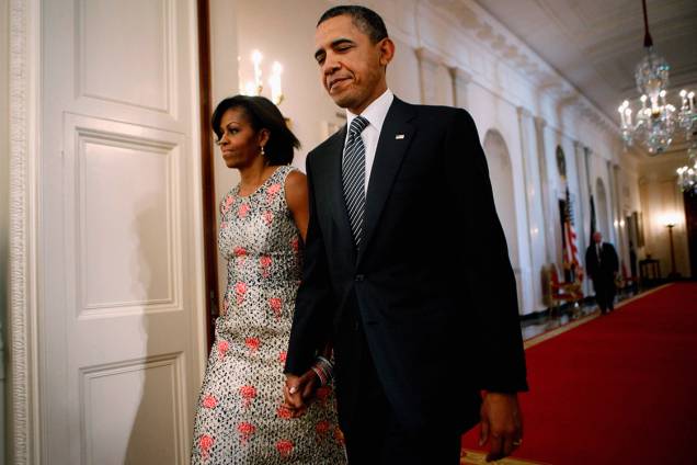 Presidente Barack Obama e a primeira-dama Michelle Obama caminham pelos corredores da Casa Branca, em Washington - 02/05/2011