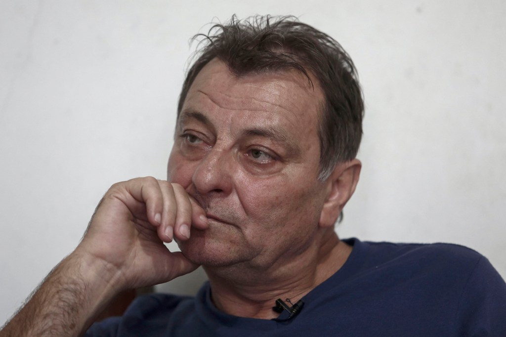 Italian ultra-leftist militant Cesare Battisti gestures during an interview with AFP in Cananeia, Sao Paulo state, Brazil on October 20, 2017. The Brazilian government wants to extradite former ultra-leftist militant Cesare Battisti to Italy, but will wait for the supreme court to resolve an habeas corpus filed by its lawyers to prevent it, Brazilian Justice Ministry Torquato Jardim said on October 13, 2017. Battisti was convicted of murder in his home country and has been on the run for decades. / AFP PHOTO / Miguel SCHINCARIOL / TO GO WITH AFP STORY by ROSA SULLEIRO