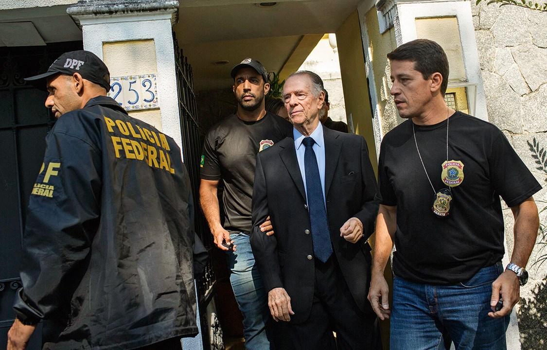 Brazil's Olympic Committee chief Carlos Nuzman (C) is escorted from his home by federal police in Rio de Janeiro on October 5, 2017. Brazilian police on October 5 arrested the chairman of the Brazilian Olympic Committee as part of a probe into alleged buying of votes to secure Rio's hosting of the 2016 Games. / AFP PHOTO / Mauro PIMENTEL