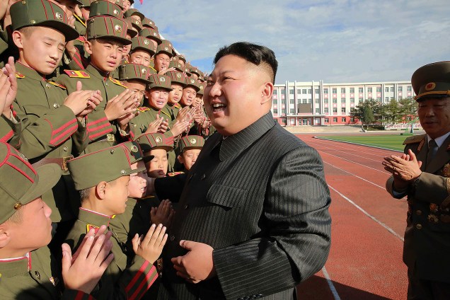 O ditador da Coreia do Norte Kim Jong-un sorri ao lado de crianças, em imagem divulgada nesta sexta-feira (13)