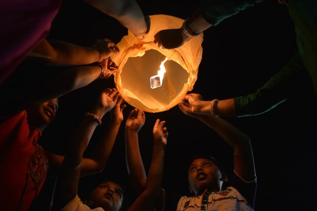 Crianças indianas, juntamente com voluntários de uma organização de cães de rua, liberam lanternas ao céu para promover uma Diwali pacífica e ecológica, alem de criar consciência para salvar animais de rua, em Siliguri, na Índia - 17/10/2017