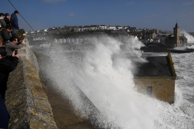 Pessoas observam as ondas gigantes que atingem as barragens do mar e o porto de Porthleven, na Cornualha, enquanto a tempestade Ophelia chega no Reino Unido - 16/10/2017