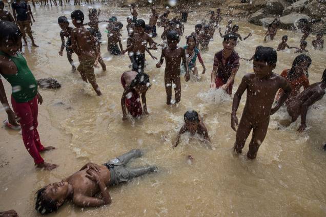 Crianças rohingyas refugiadas brincam nas águas de um pequeno riacho que passa pelo campo de Kutupalong, em Cox's Bazar, no Bangladesh - 06/10/2017