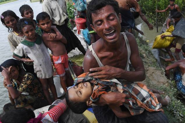 Um refugiado rohingya têm o filho morto em seus braços após atravessar o rio Naf, chegando em Whaikhyang, no Bangladesh. Um membro da ONU diz que o plano de construir um acampamento para mais de 800.000 muçulmanos que fogem de Myanmar devido às repressões, era perigoso porque a superlotação poderia aumentar os riscos de doenças mortais, espalhando-se rapidamente - 09/10/2017
