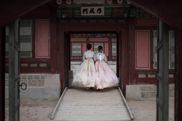 Duas mulheres usam o vestido tradicional hanbeok coreano na entrada do palácio Gyeongbokgung, em Seul, durante o feriado Chuseok, de uma semana no qual as famílias geralmente oferecem agradecimentos e orações a seus antepassados - 03/10/2017