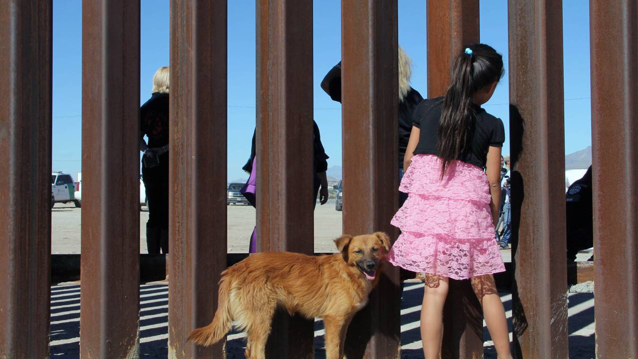 Imagens do dia - Criança na fronteira entre México e EUA
