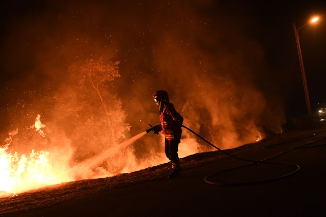 Um bombeiro trabalha para conter as chamas de um incêndio que atingiu Cabanões, perto de Lousã, em Portugal. Pelo menos 27 pessoas morreram em incêndios que devastaram florestas no norte e no centro do país nas últimas 24 horas - 16/10/2017