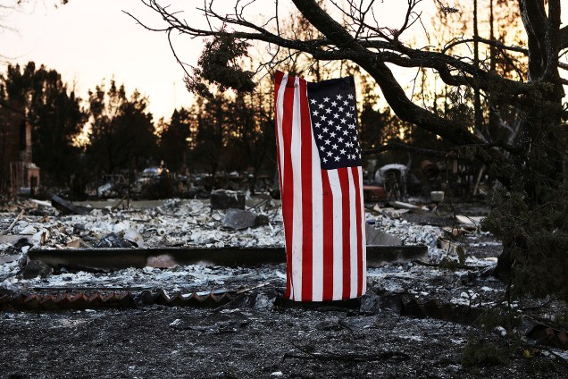 Bandeira dos EUA é vista pendurada em uma árvore de um bairro destruído por um incêndio florestal em Santa Rosa, na Califórnia - 13.10/2017