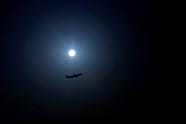Um avião é fotografado decolando durante o nascer da lua no aeroporto internacional da capital do  Kuwait - 09/10/2017