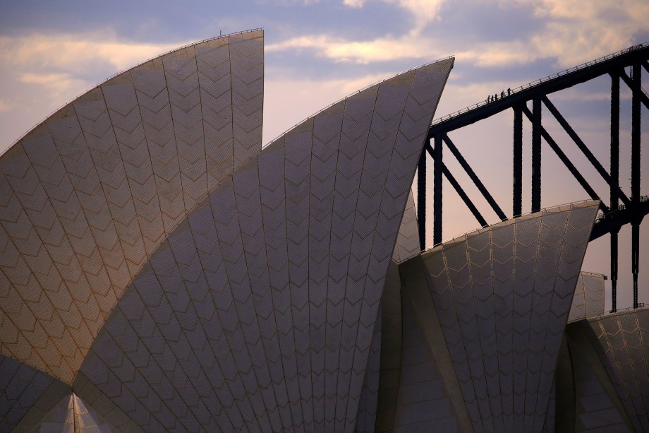 Alpinistas são vistos subindo o arco da Ponte do Porto de Sydney por trás do telhado da Ópera de Sydney na Austrália - 30/10/2017