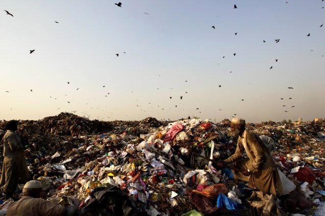 Um homem é fotografado coletando materiais para reciclar em um lixão de Islamabad, capital do Paquistão - 11/10/2017