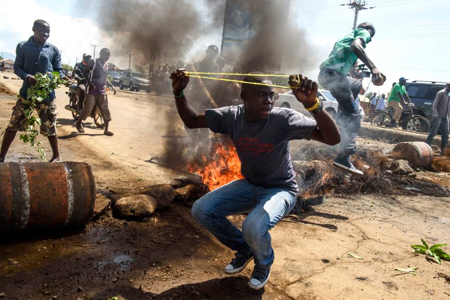 Partidários do candidato presidencial da Super Aliança Nacional (NASA) Raila Odinga lançam pedras e bloqueiam uma estrada, durante manifestação sobre o boicote das próximas eleições em Kisumu, no Quênia - 25/10/2017