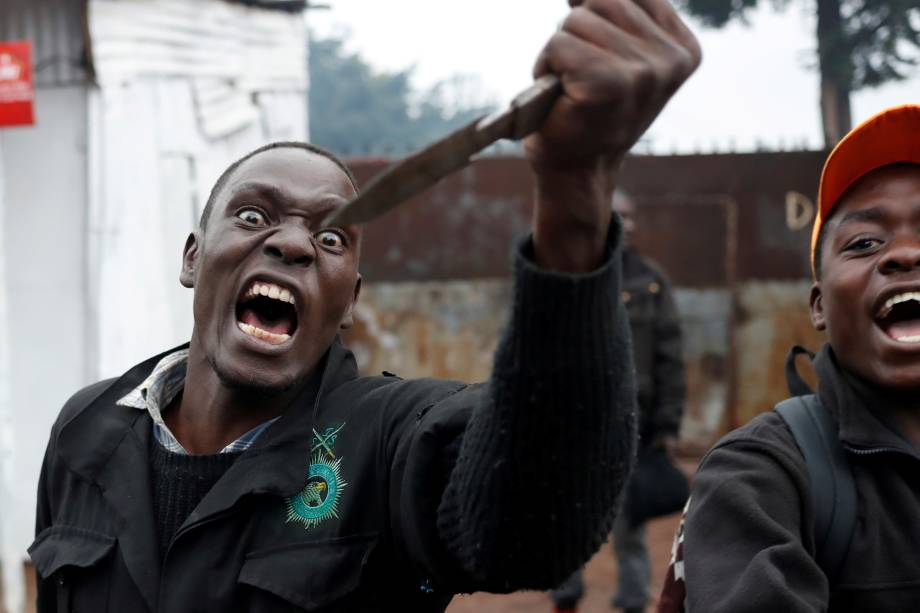Manifestante de oposição grita com uma faca na mão durante confrontos com a políciai na favela de Kibera em Nairóbi, no Quênia - 26/10/2017