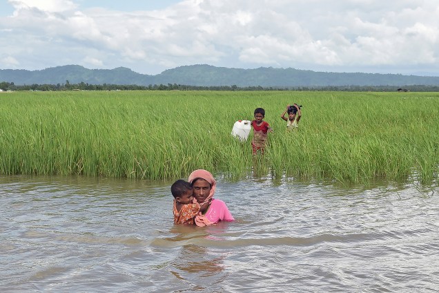 Khalida, um refugiado rohingya atravessa um rio com seus três filhos próximo à fronteira entre Myanmar e Bangladesh. A família faz parte dos 600 mil refugiados que estiveram em Bangladesh desde agosto, fugindo da violência no estado de Rakhine - 18/10/2017