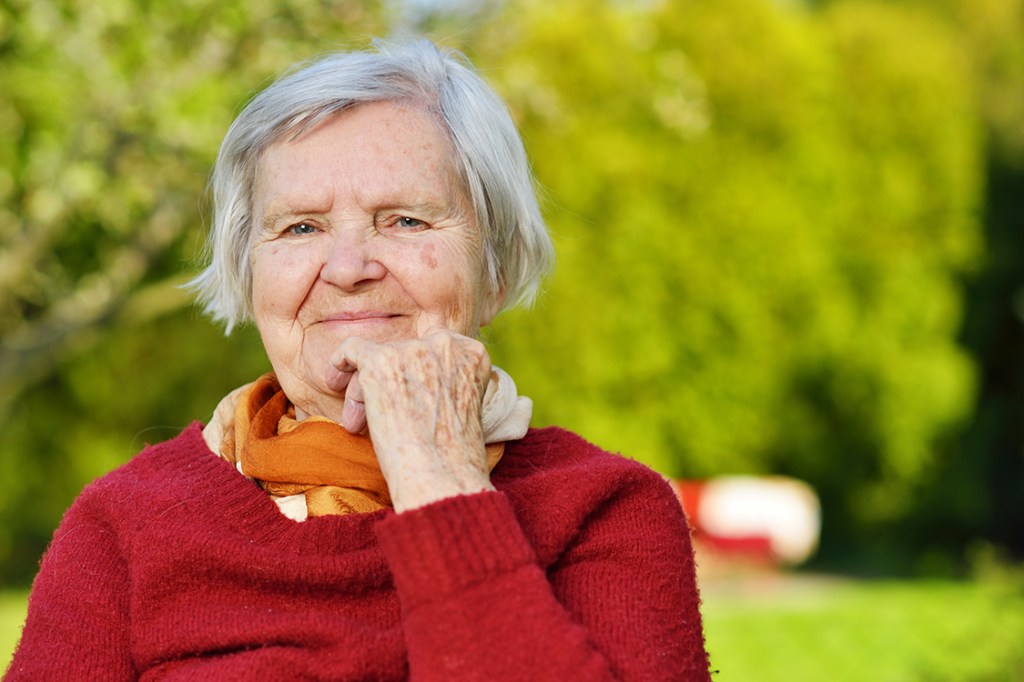 Senhora idosa sorrindo em um jardim